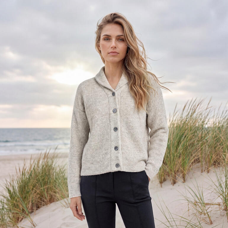 Femme en cardigan bonheur Fisherman beige sur la plage avec la mer
