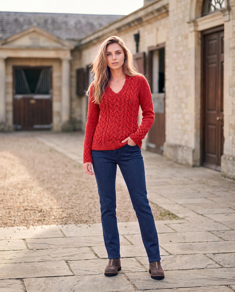 Femme en pull à torsades rouge Horseshoe, posture décontractée en extérieur