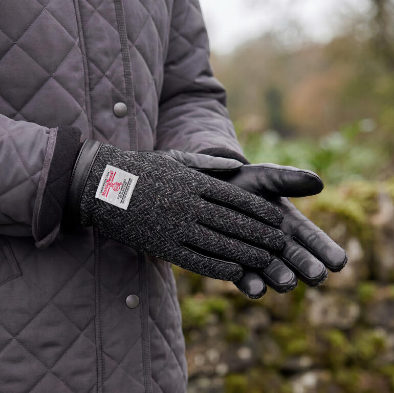 Gants noirs en tweed de Harris sont visibles en gros plan.