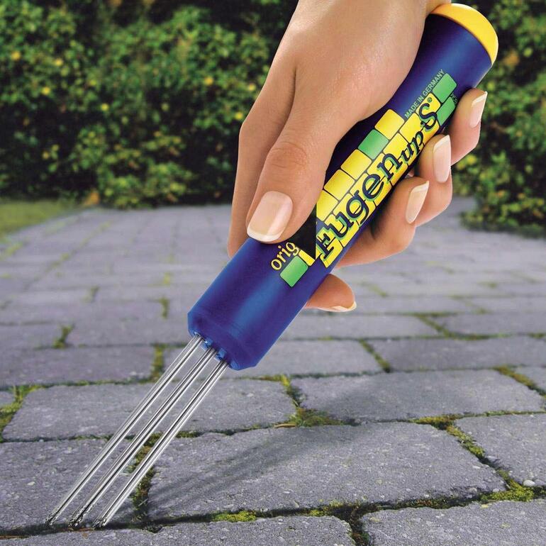 Nettoyant pour joints tenu à la main pour nettoyer les joints.